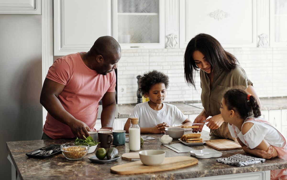 Homem cozinhando com seus filhos.