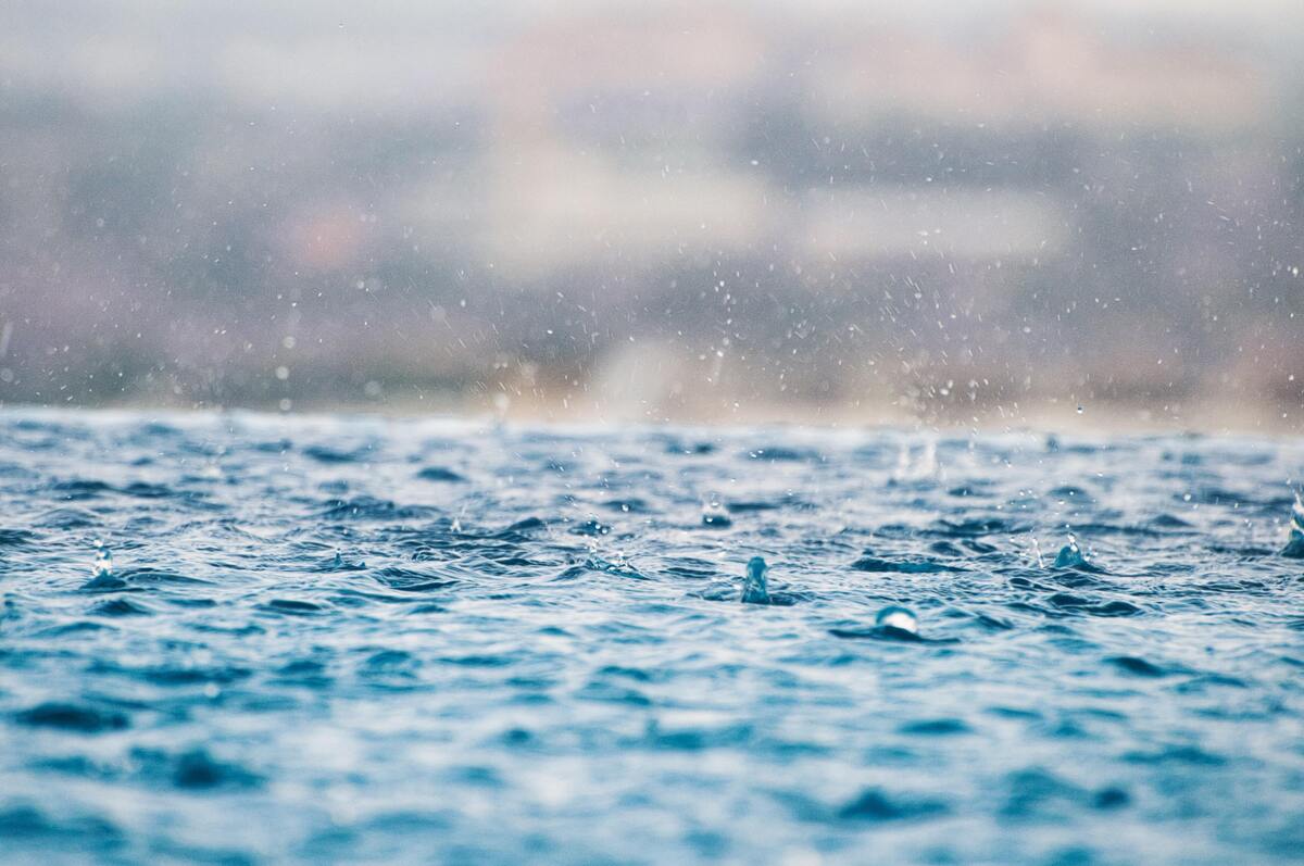 Pingos de chuva caindo na água. 