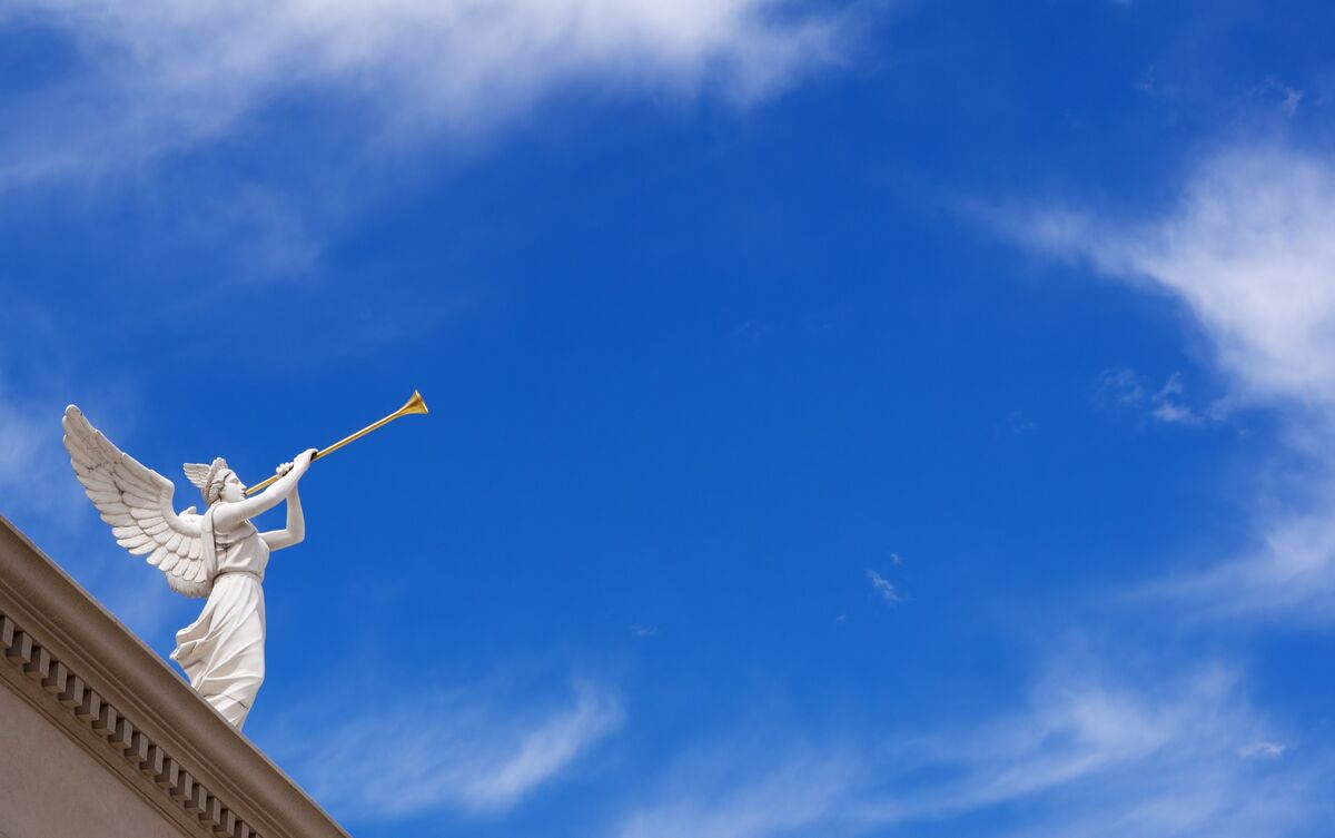 Estátua de arcanjo no topo de construção.