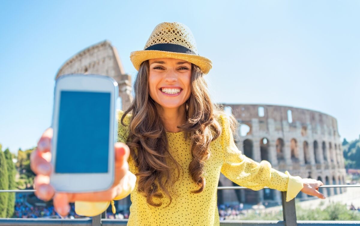 Mulher turista segurando celular.