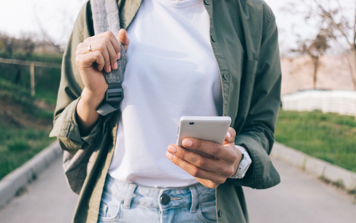 Mulher usando celular na rua.