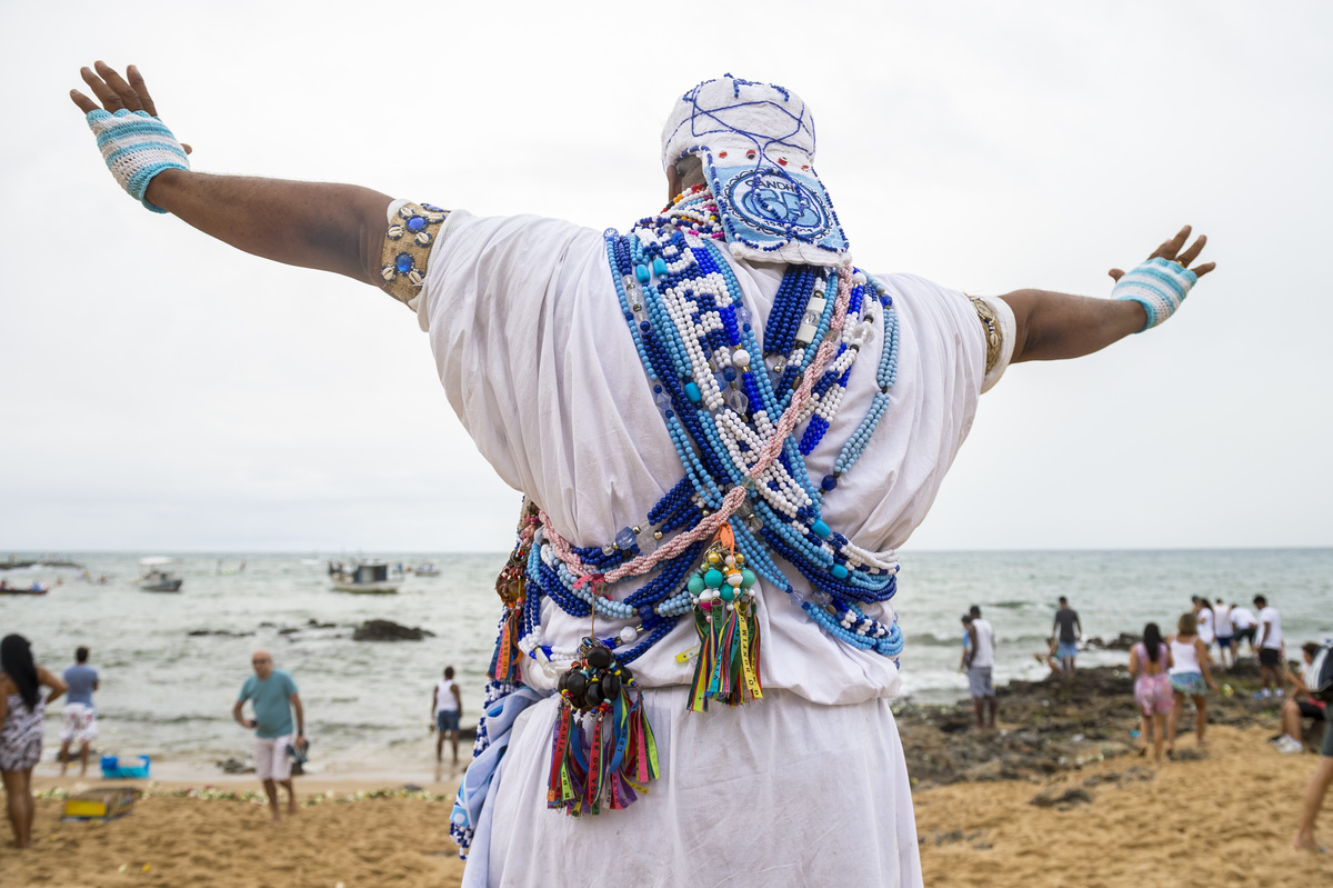 Homem de religião Candomblé de braços abertos.