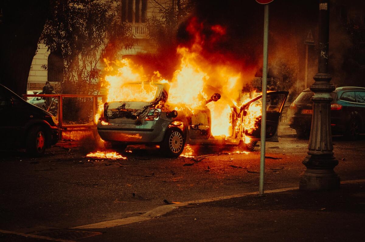 Carro pegando fogo na rua.