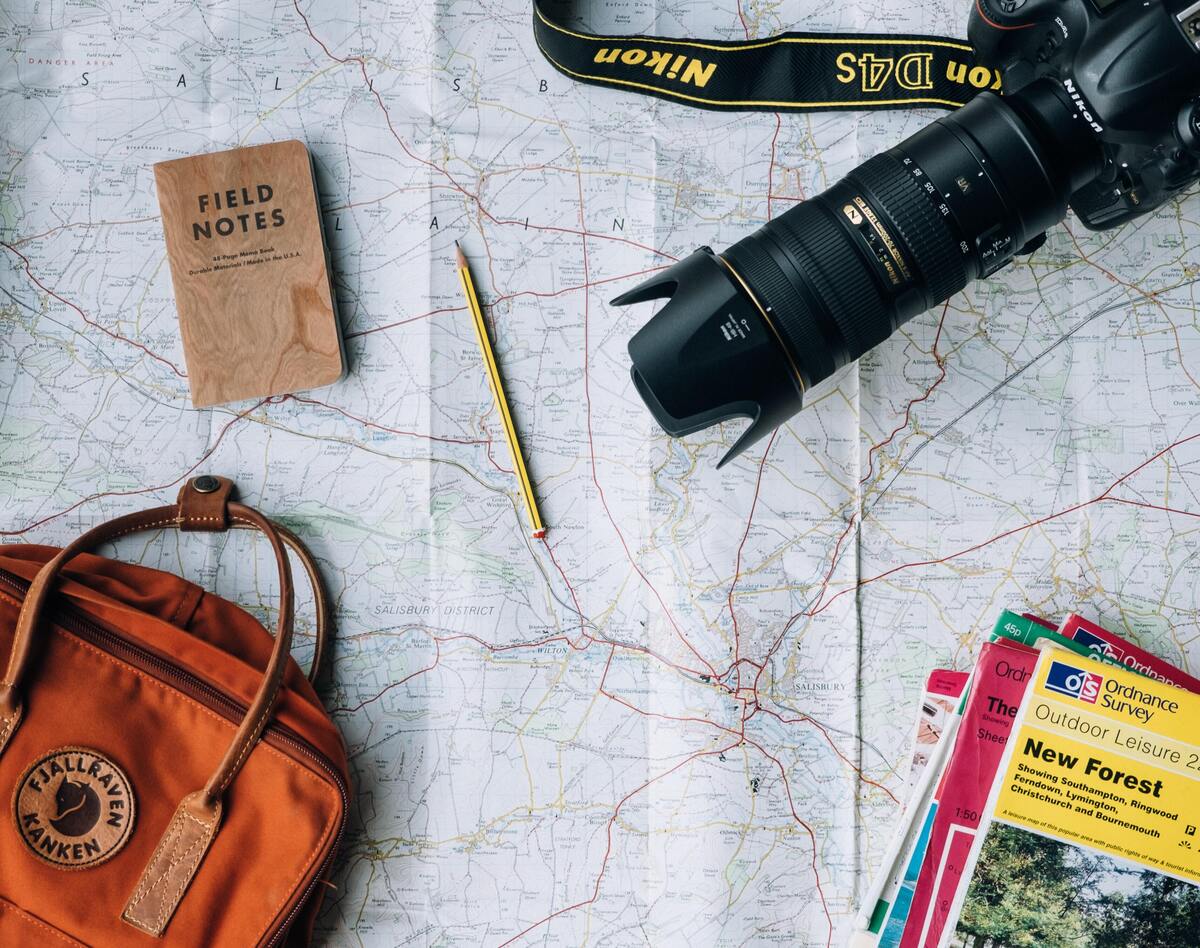 Utensílios de viagem em cima de um mapa. 