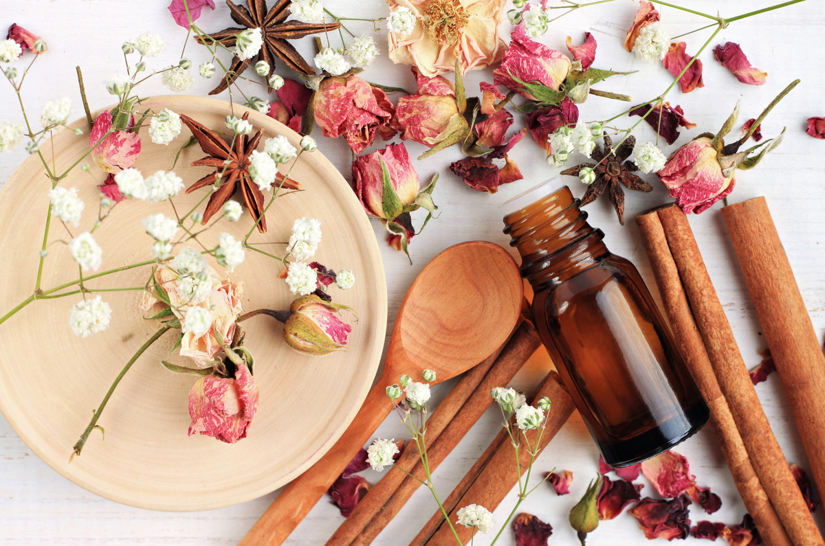 Paus de canela e rosas em cima de uma mesa.