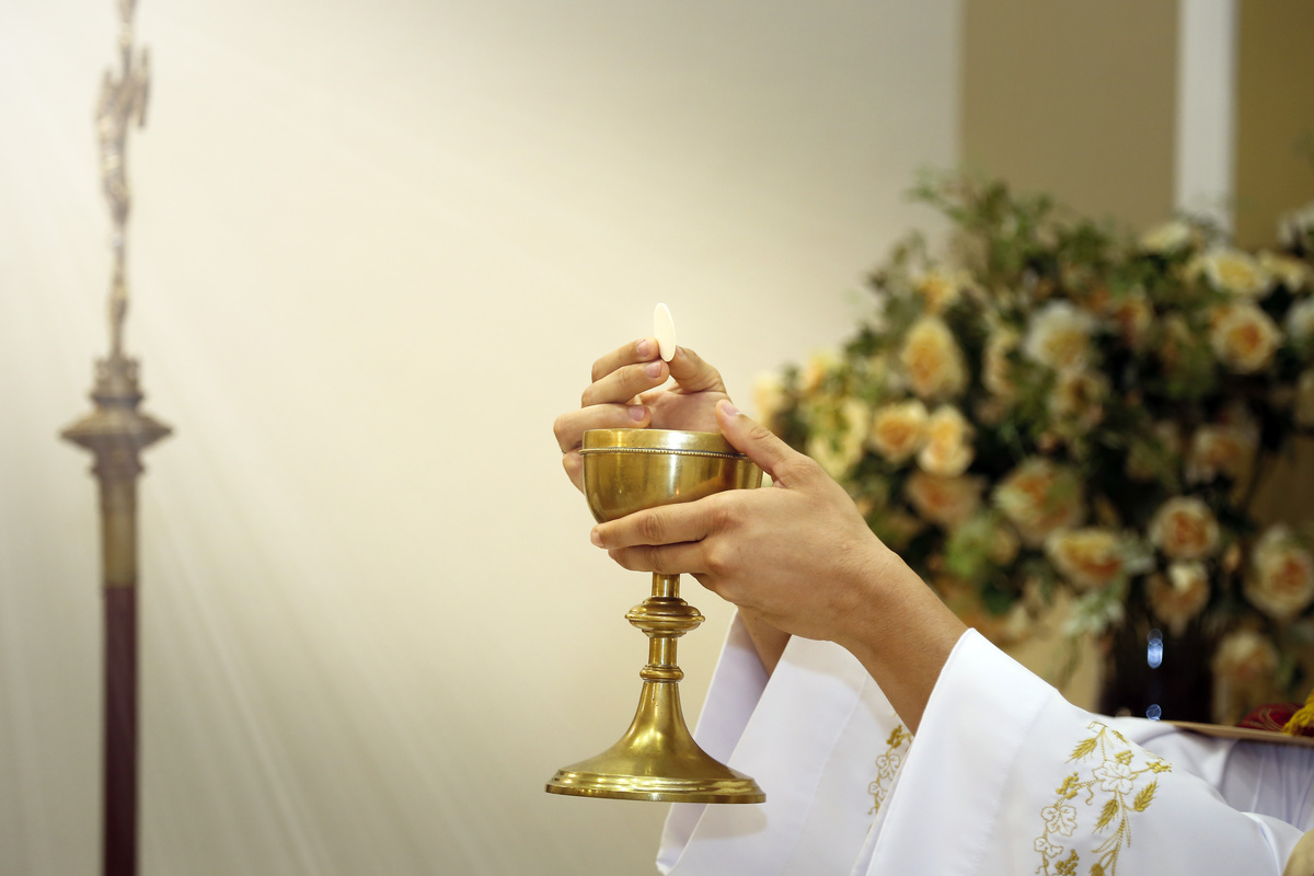 padre dando hóstia