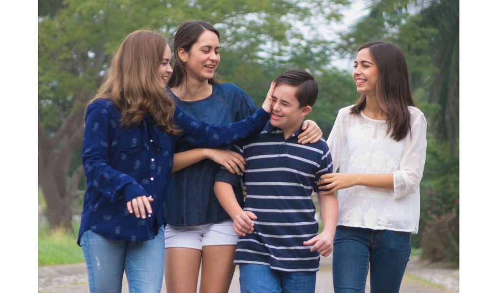 Quatro irmãos caminhando juntos, três irmãs e um menino.