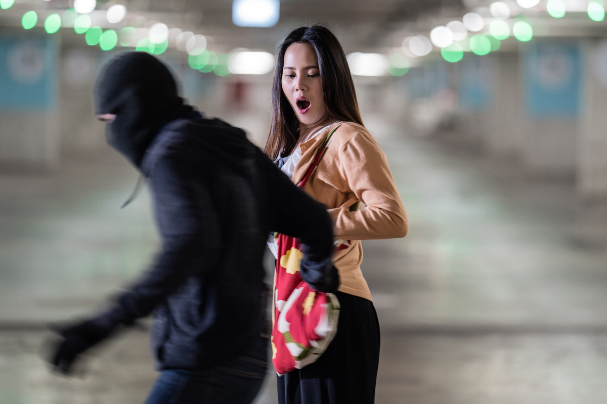 Um homem mascarado segurando no braço de uma mulher