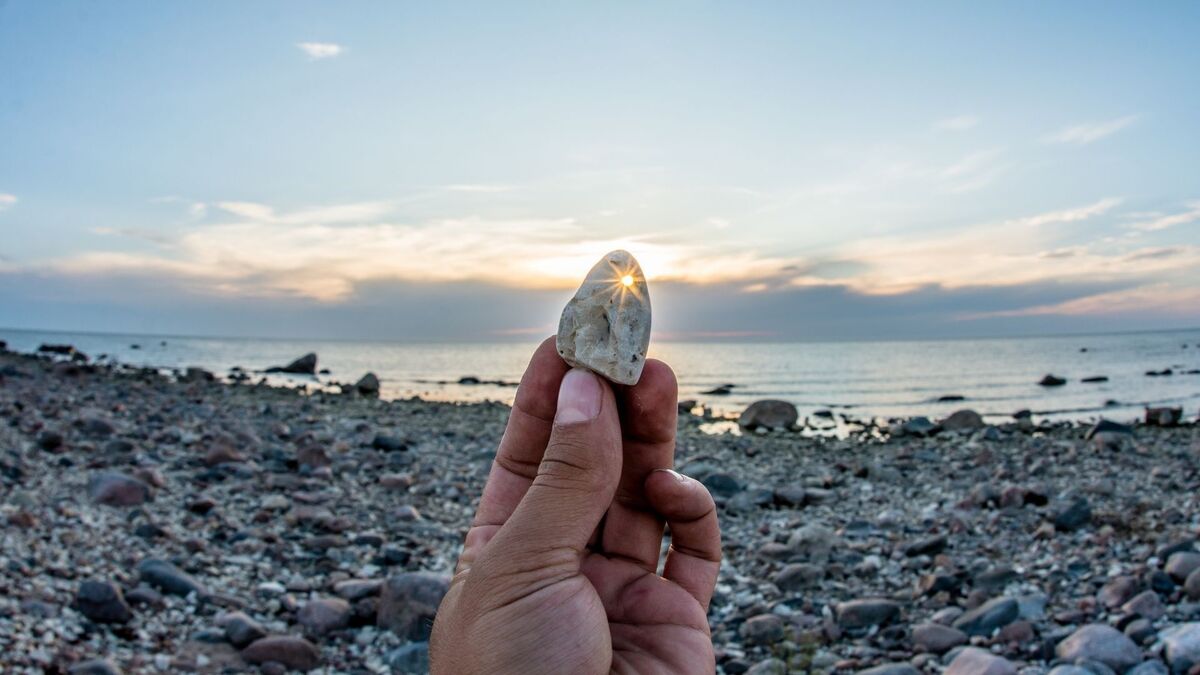 Mão segurando uma pedra.