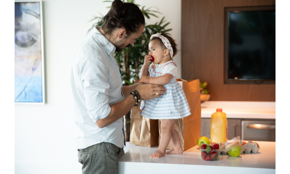 Pai com sua filha bebê em uma mesa.