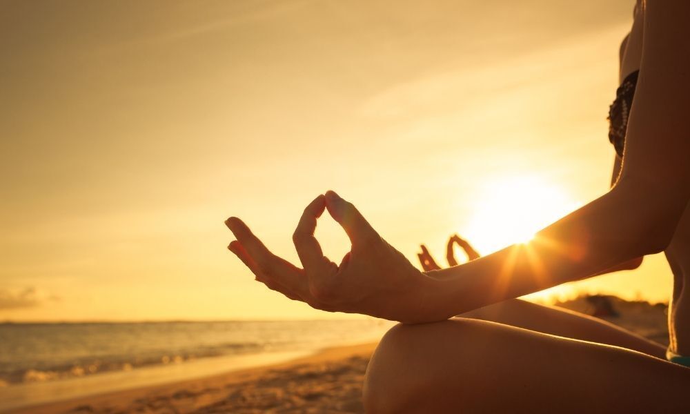 pessoa meditando na praia