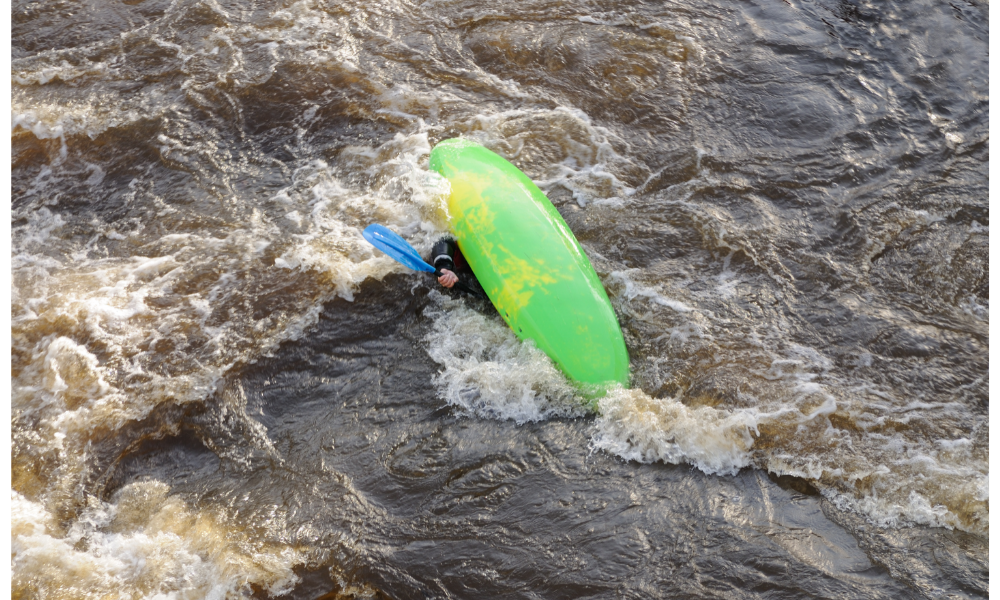 Canoa da cor verde virada no mar.