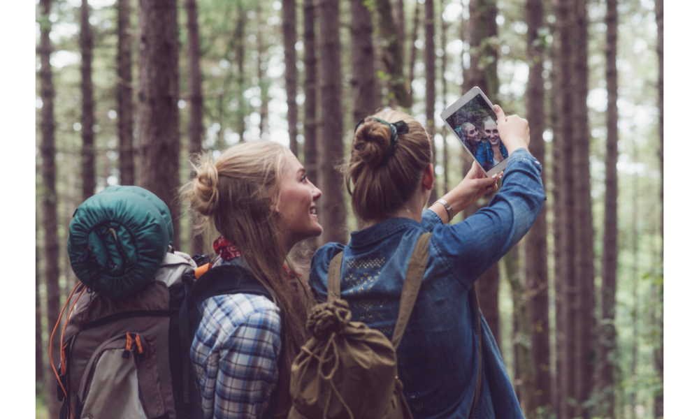 Três amigas em uma floresta tirando foto.