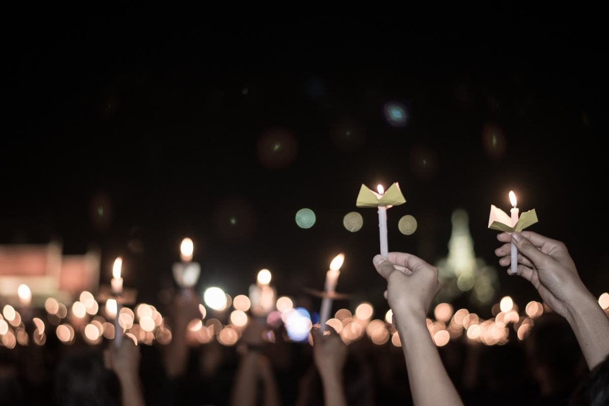 Procissão com velas com muitas pessoas.