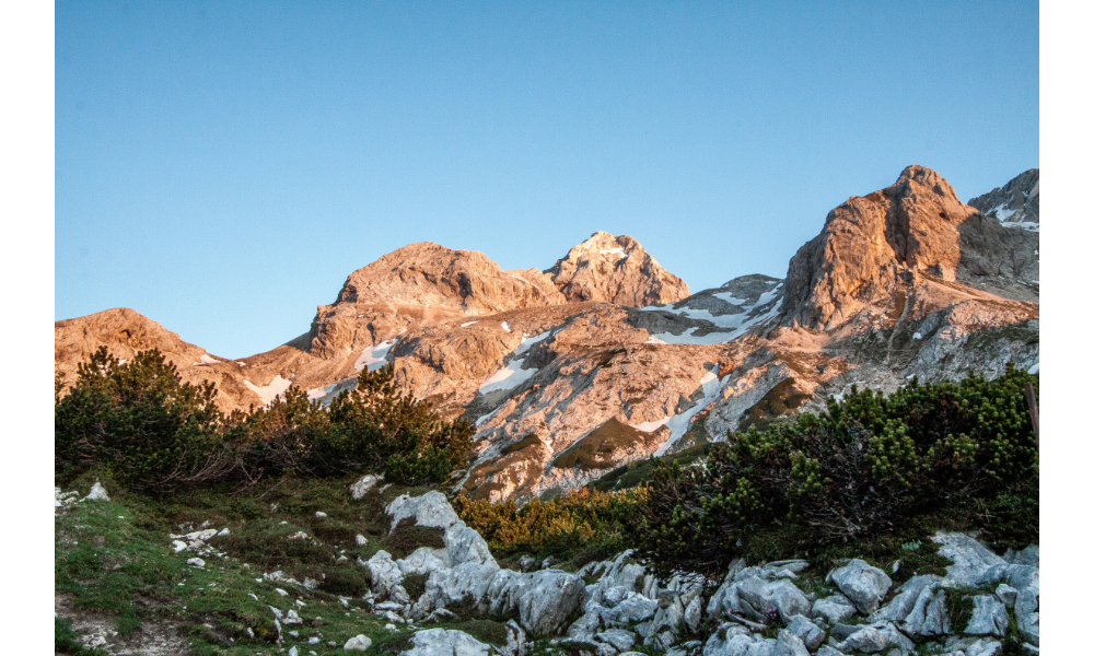 Montanhas com neve e grama.