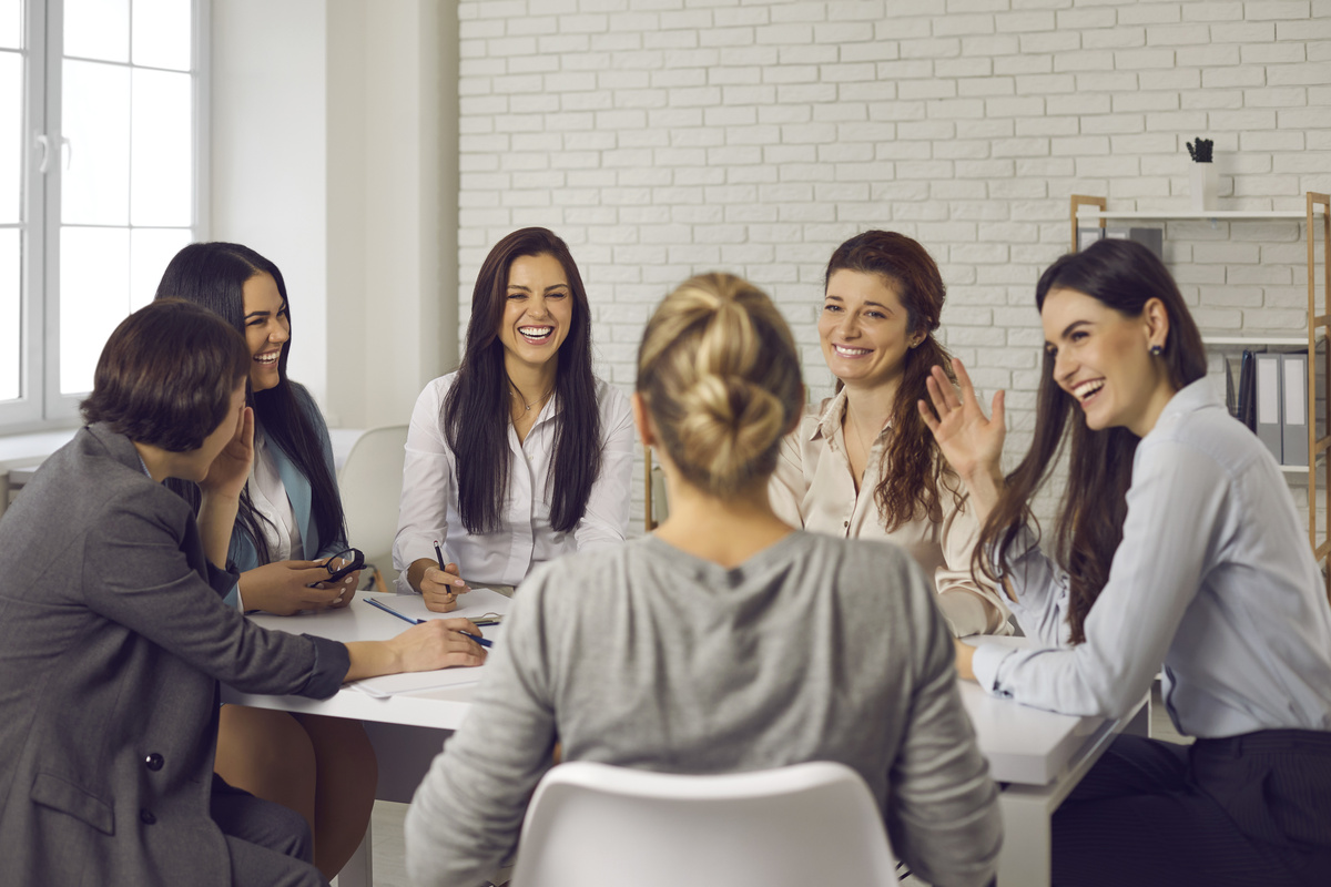 Várias mulheres reunidas em volta de uma mesa