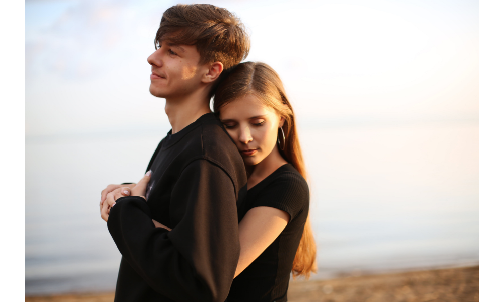 Casal de abraçando em uma praia.