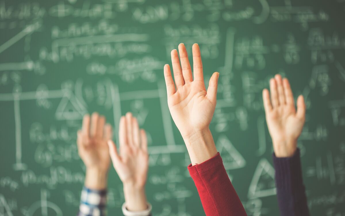 Mãos levantadas em aula.