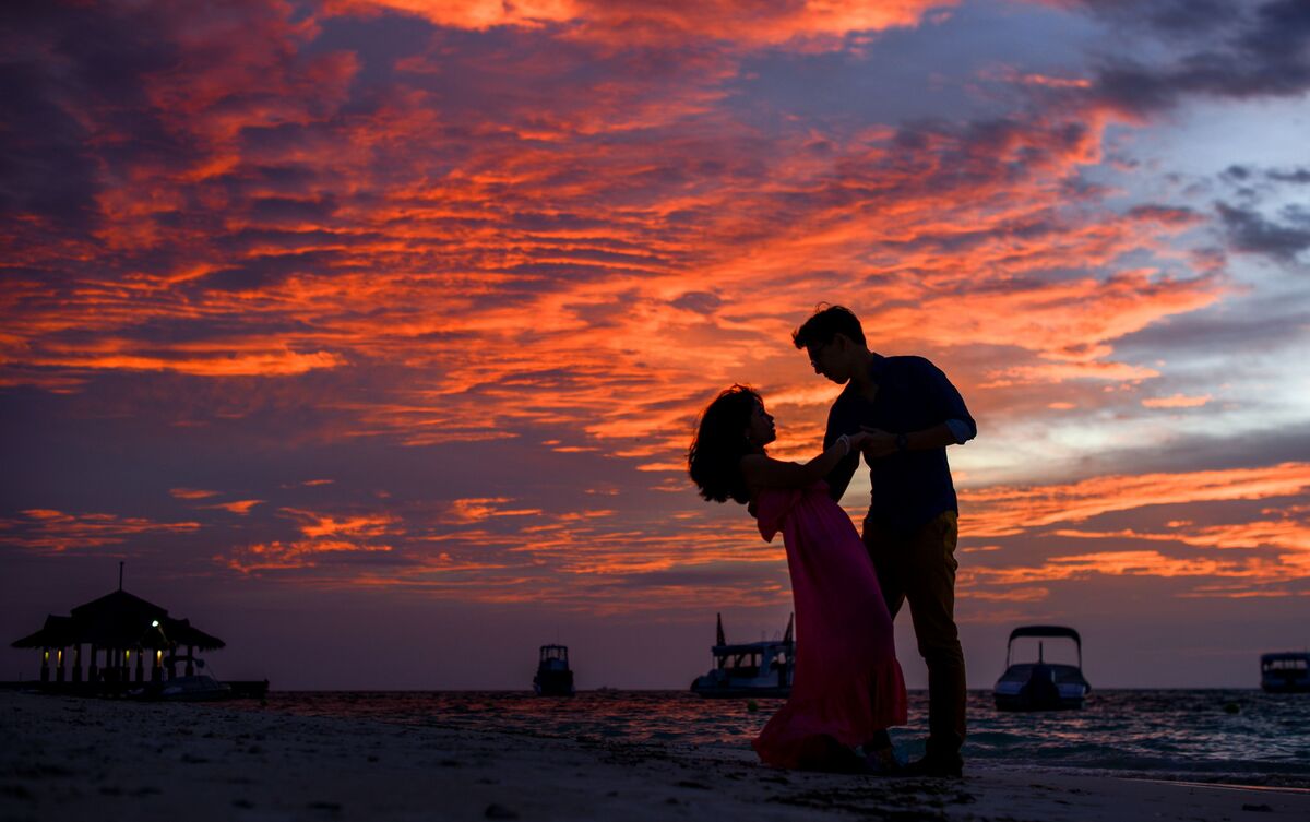 Casal abraçado ao pôr do sol.