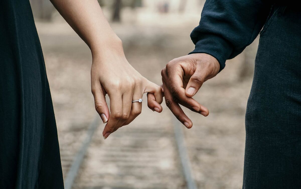 Casal de mãos dadas.