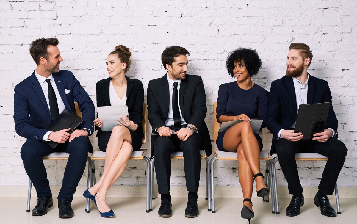 Pessoas sentadas em ambiente de trabalho.