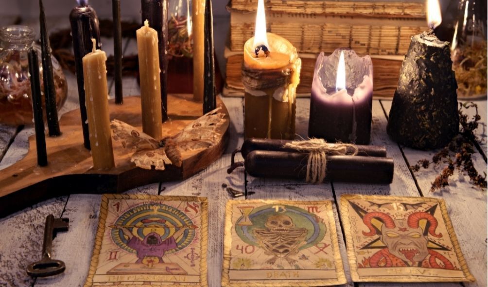 Cartas de tarot em mesa de tiragem, com velas ao redor