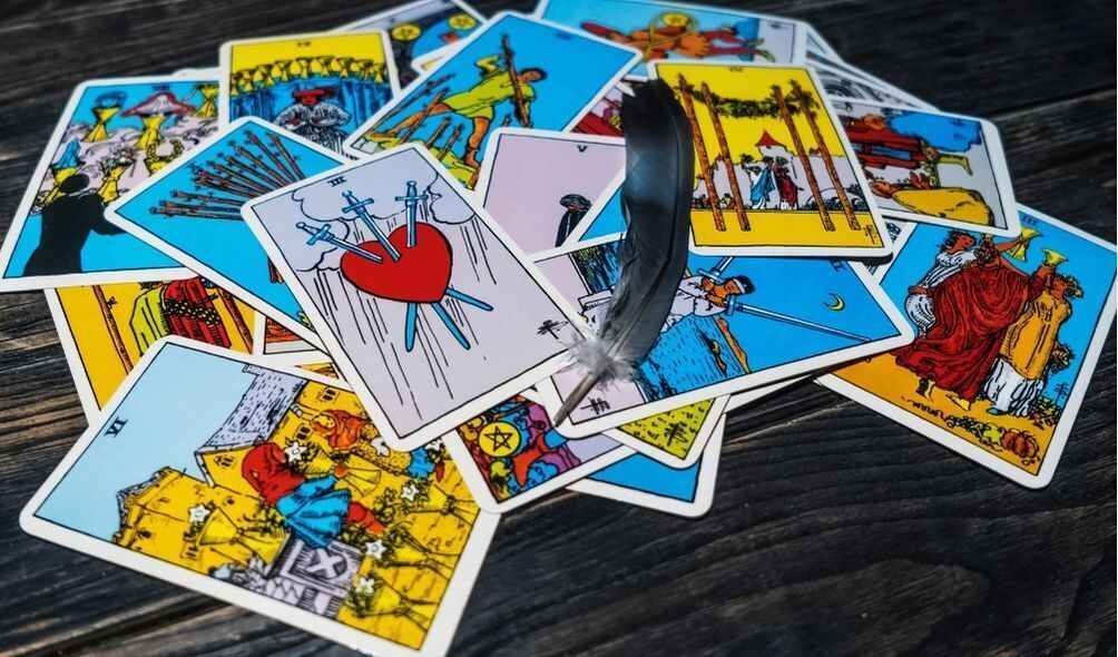 Cartas de tarot com uma pena em cima