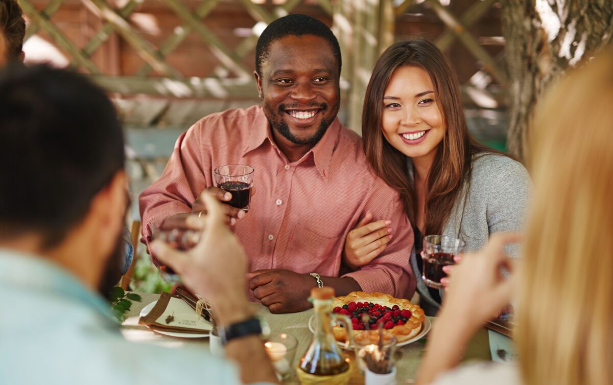 Casal de homem e mulher em reunião de amigos.