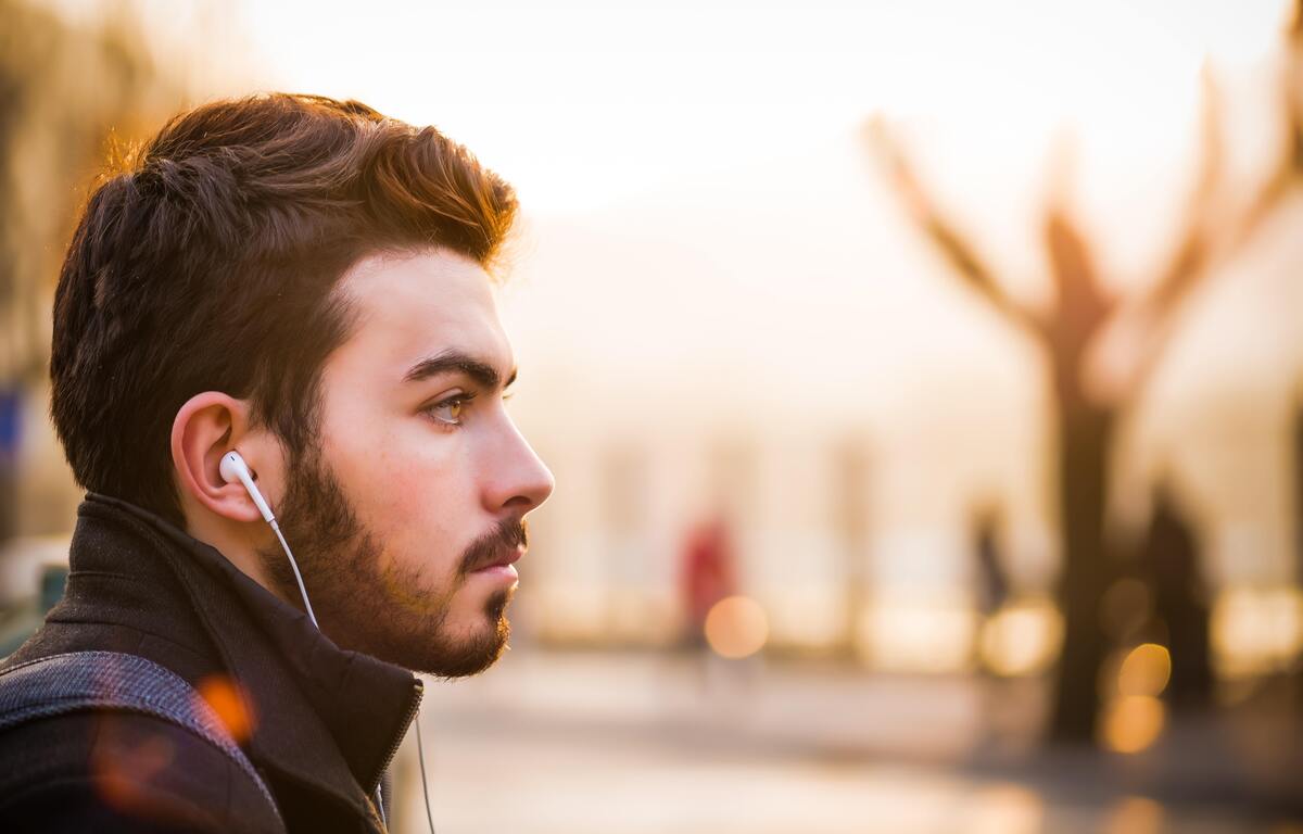 Homem de perfil com fones de ouvido. 