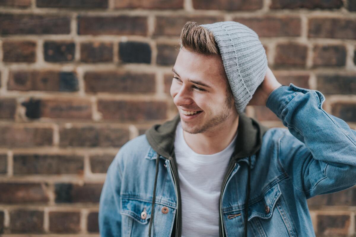 Homem sorrindo com a mão na cabeça. 