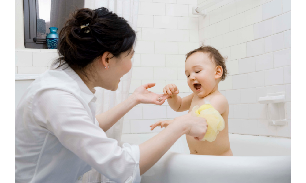 Mãe dando banho no filho bebê.