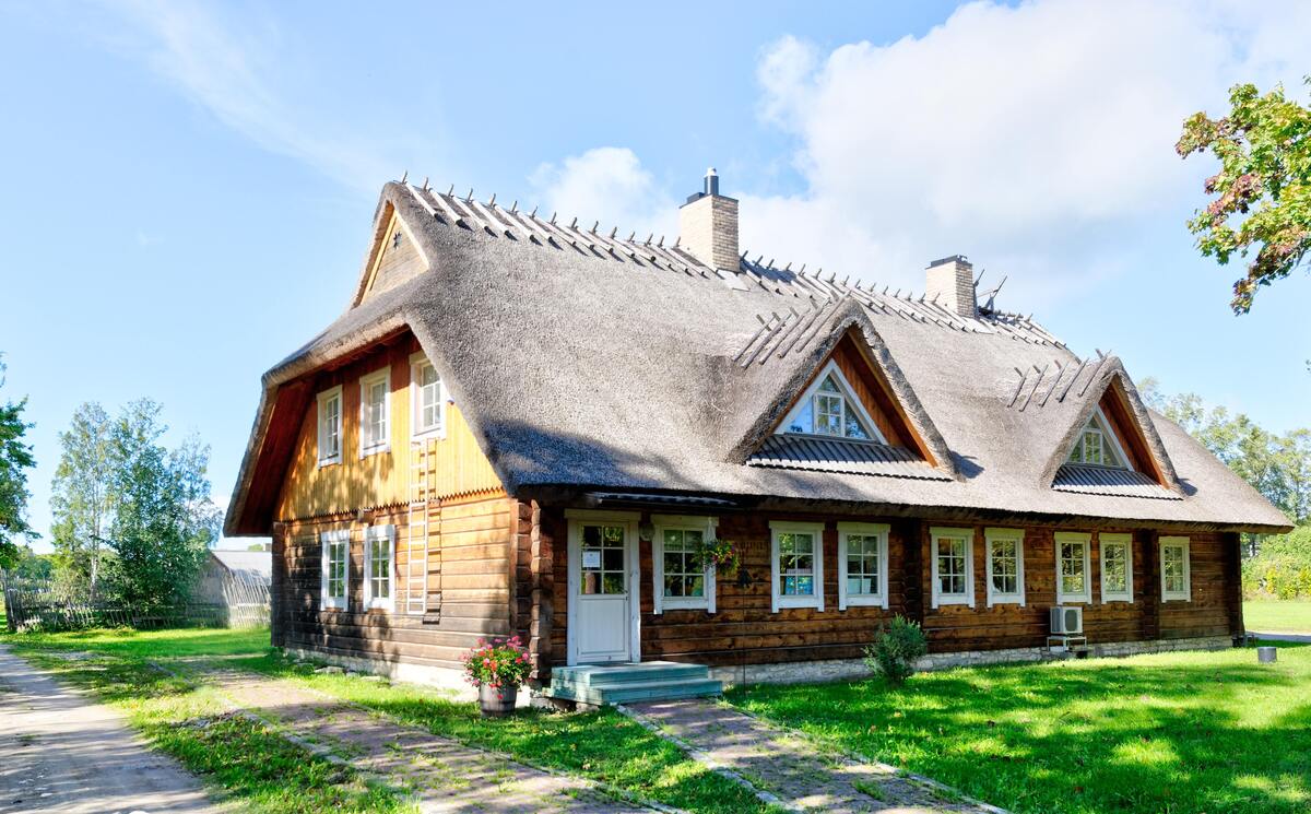 Casa cercada por um campo gramado.