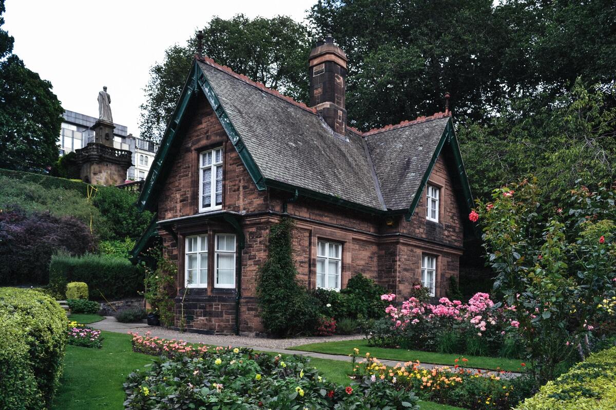 Casa cercada por um jardim com flores. 