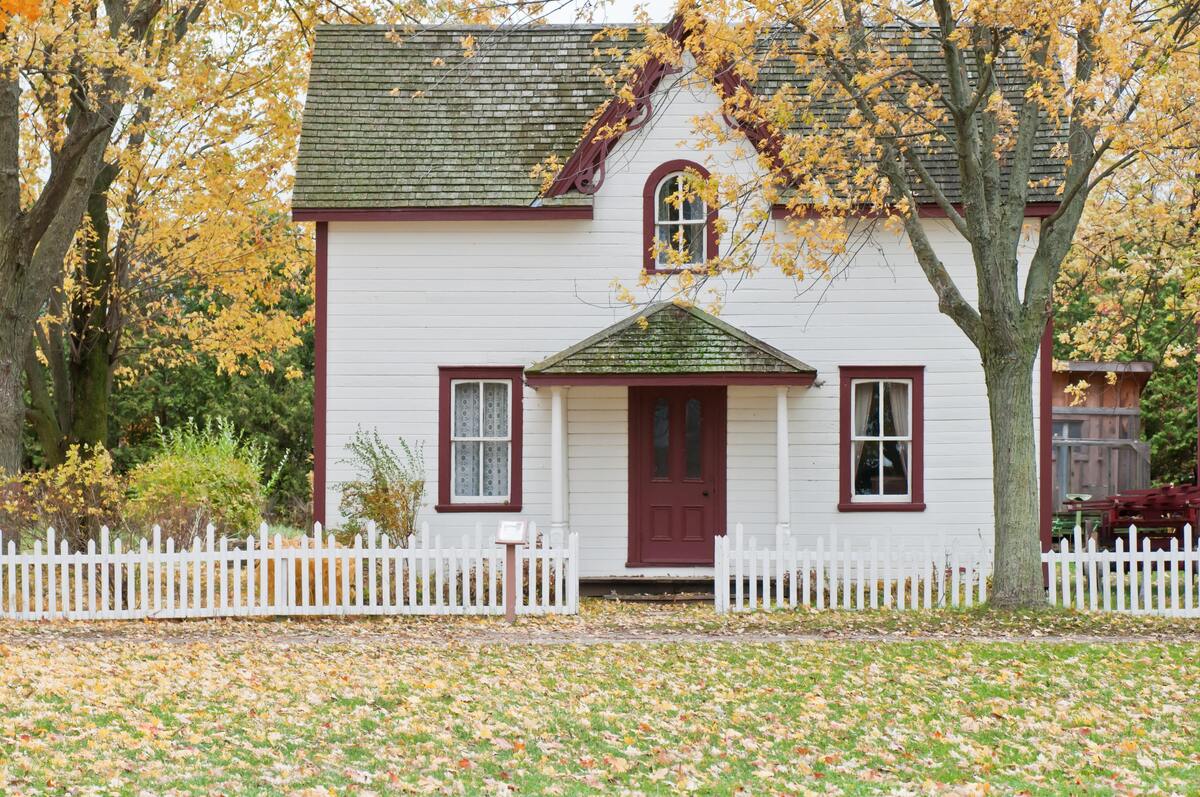 Casa clássica americana, cercada por campo gramado. 