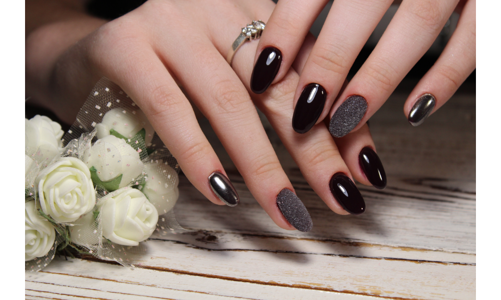 Mãos com unhas pintadas de preto.