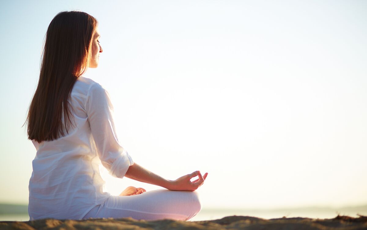 Mulher meditando ao ar livre.