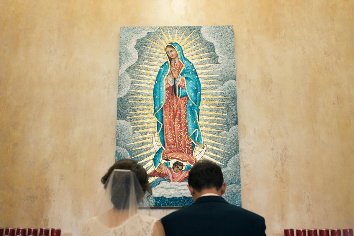 Casal observando imagem de Nossa Senhora Aparecida.