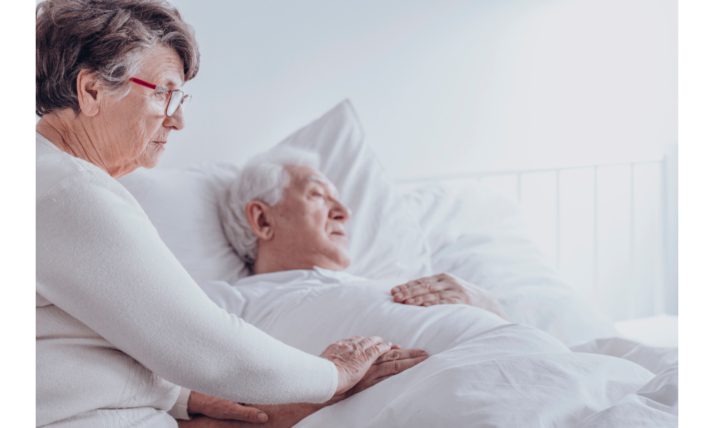 Senhora cuidando do marido doente em uma cama.